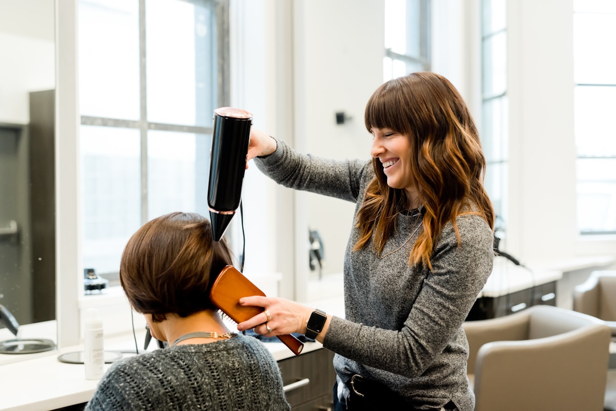 Premium Pflegeprodukte und Handtücher im Korb – Elena's Hair Studio