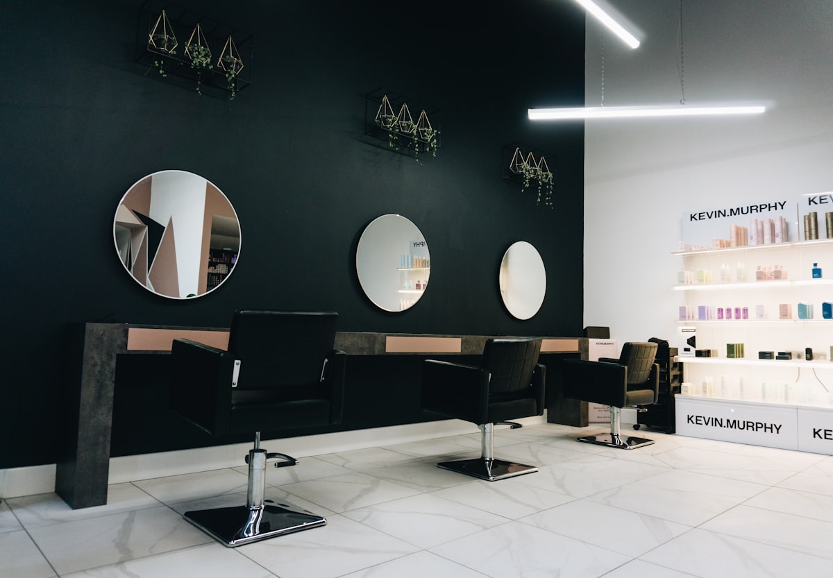 Eleganter Empfangsbereich des Salons mit modernem Holztresen und warmem Licht