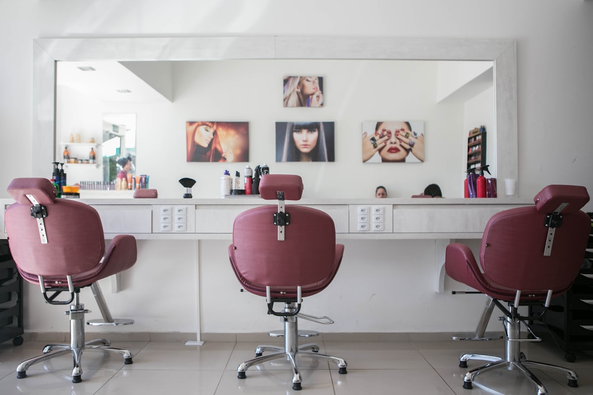 Professionelles Föhnen und Styling im eleganten Friseursalon – warme beige Atmosphäre