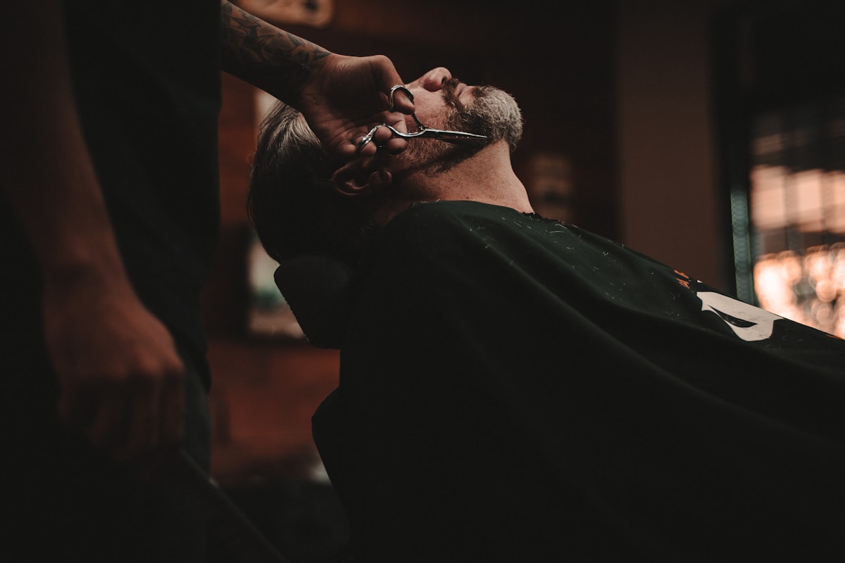 Friseurin beim Bürsten einer Kundin im eleganten Salon – warme Atmosphäre